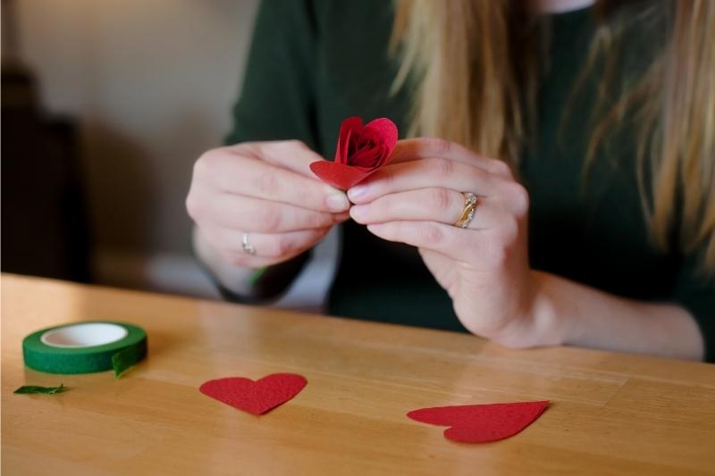 Kvinde laver røde papirblomster diy