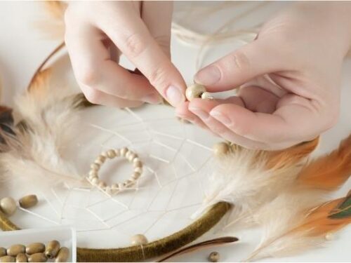 kvinde laver drømmerfanger med perler og fjer